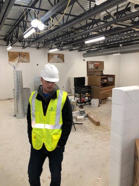 A construction worker in a room that is under construction.